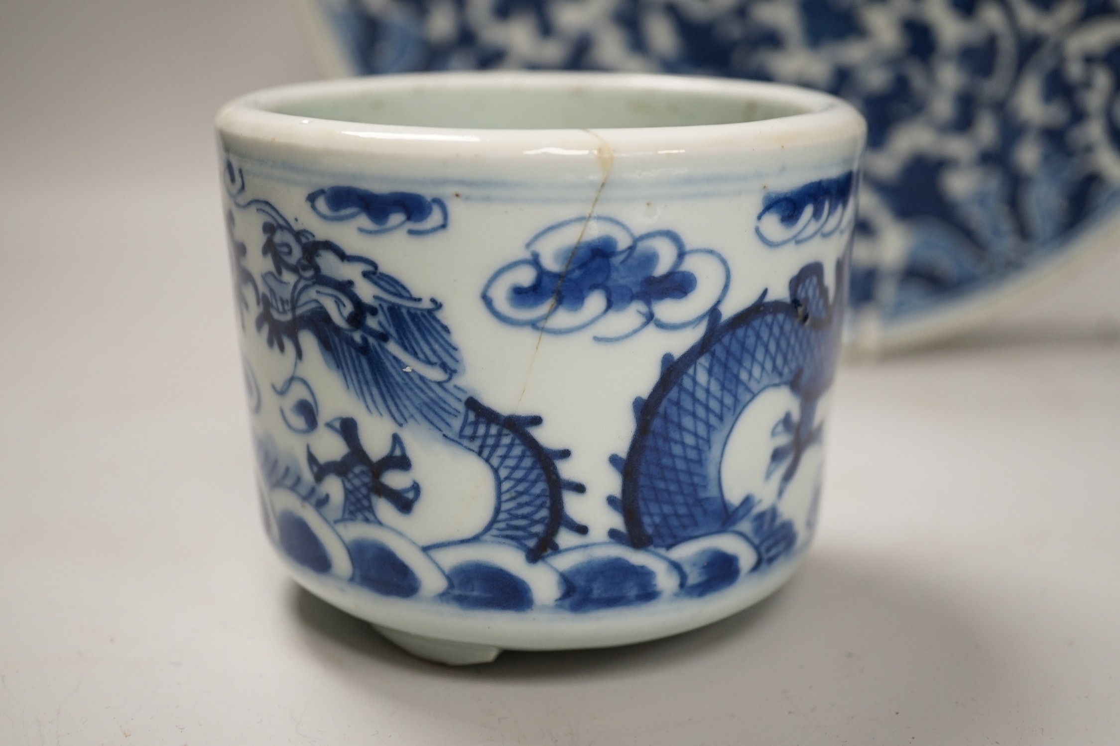 A Chinese blue and white ‘lotus’ charger, together with a bowl and dragon pot on tripod base